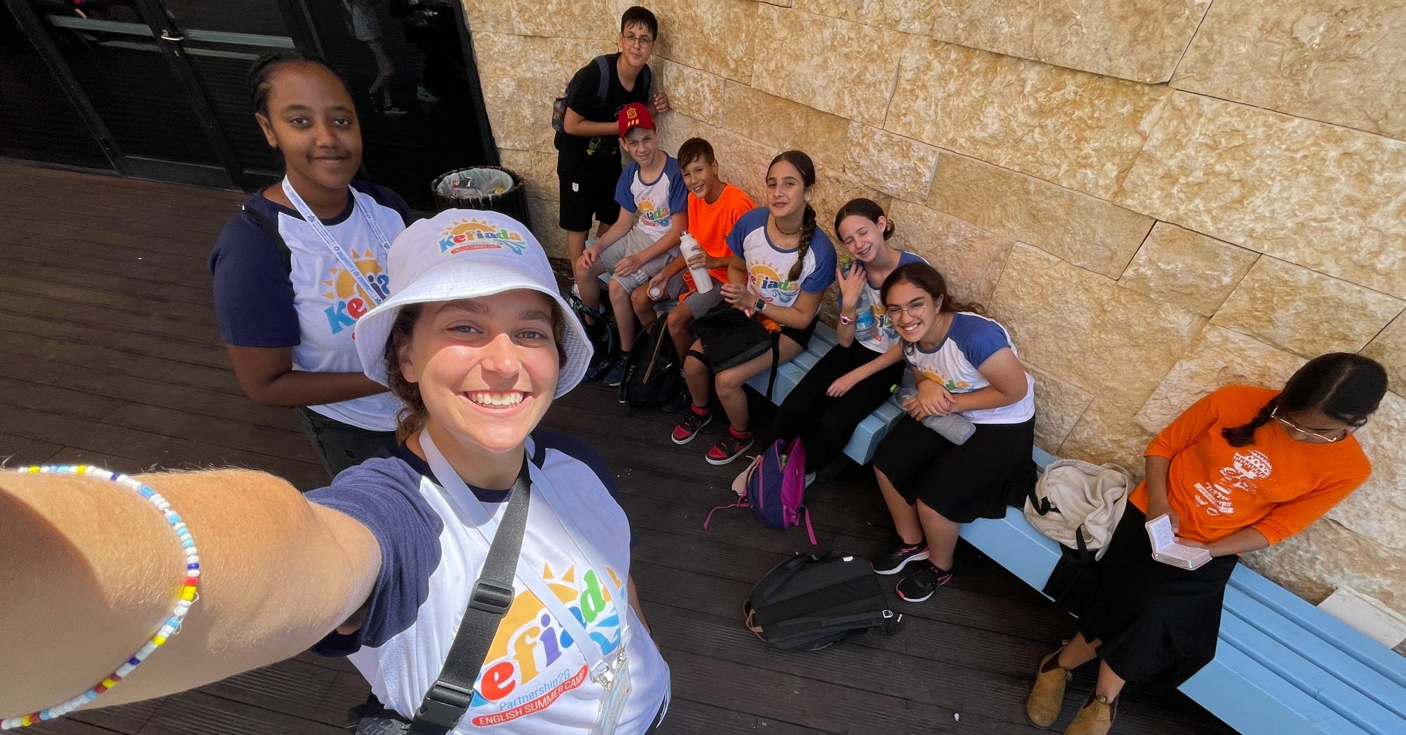 A selfie of a counselor and her campers wearing "Camp Kefiada" t shirts in Kiryat Gat.