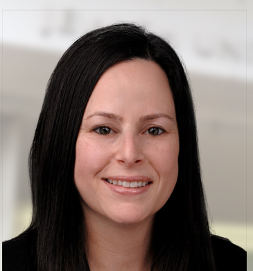Executive Director of Public Affairs Tracy Moore head shot with black hair, dark eyes and a black suit.