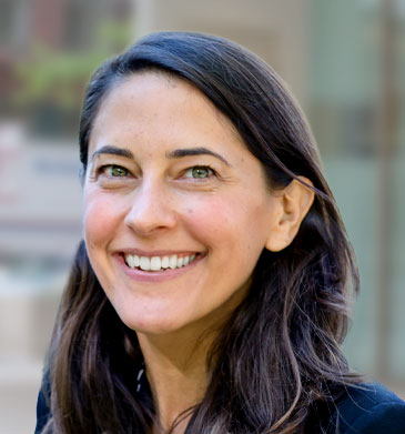 Chief Impact Officer Emily Sweet headshot smiling with brown hair, light eyes and blue suit.