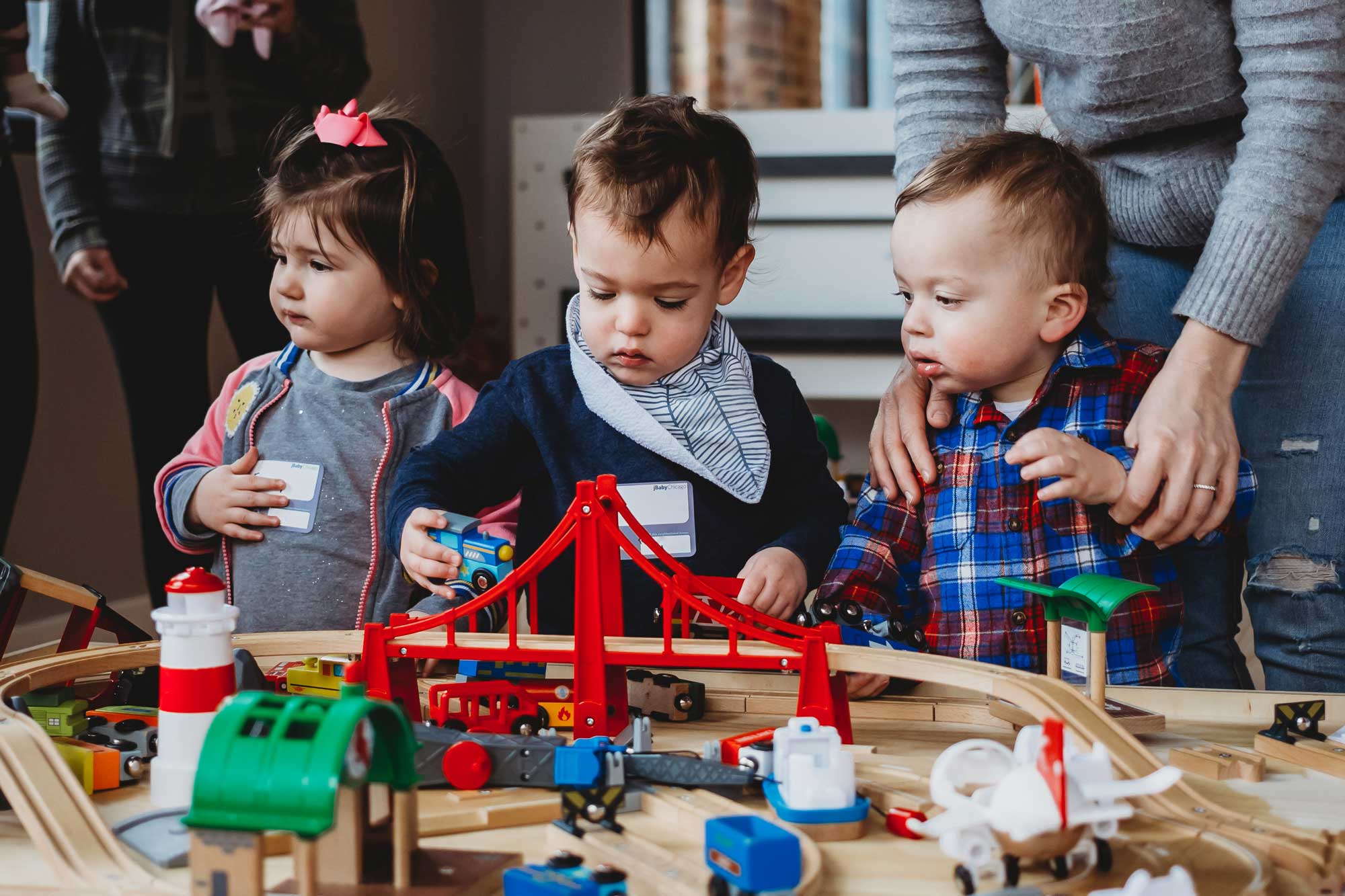 toddlers playing with toy trains