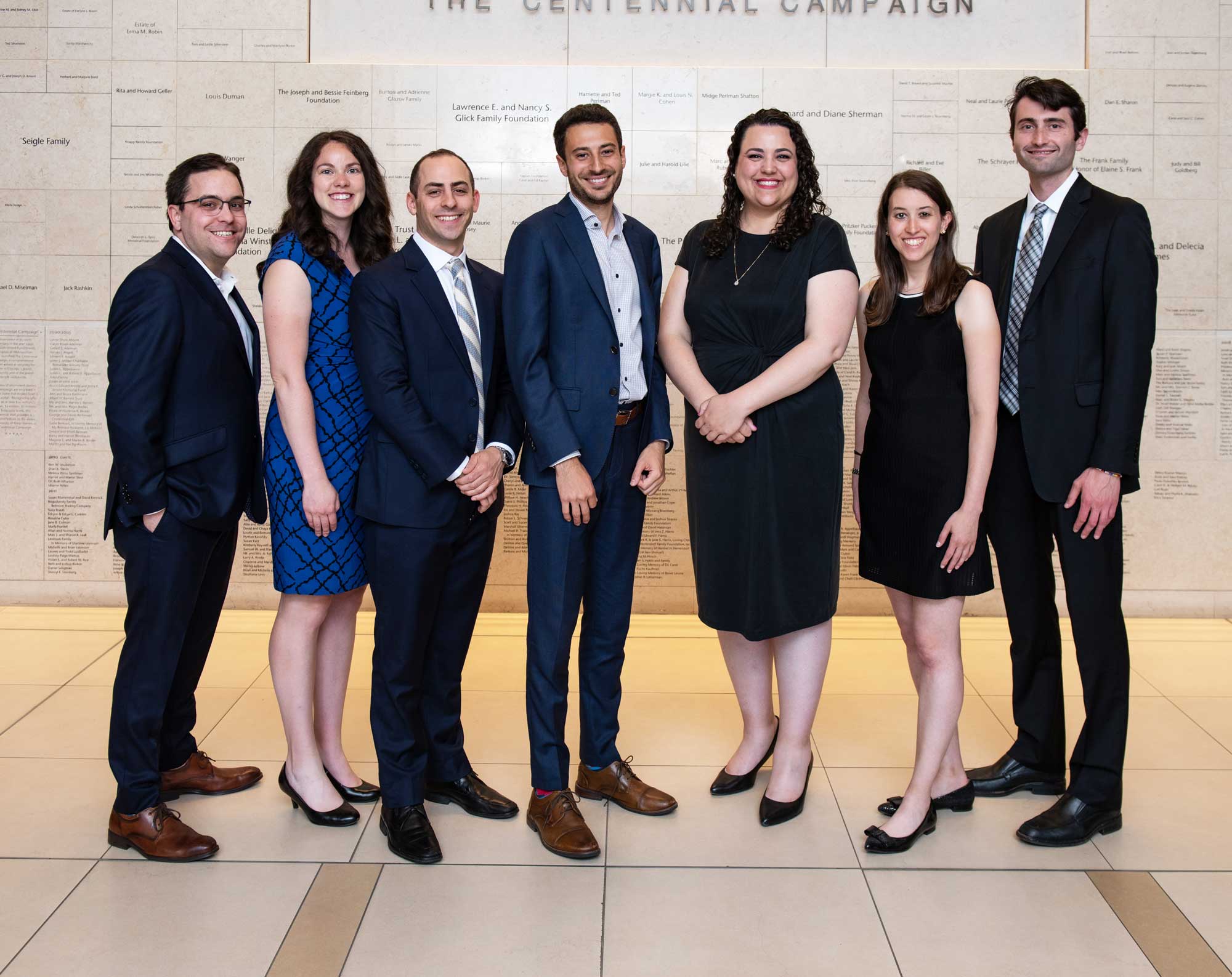 Seven young adults who make up the YLD Board dressed in business clothes posed smiling.