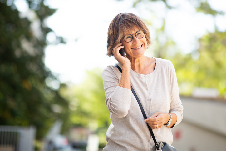 Portrait older woman talking with cellphone outdoors.