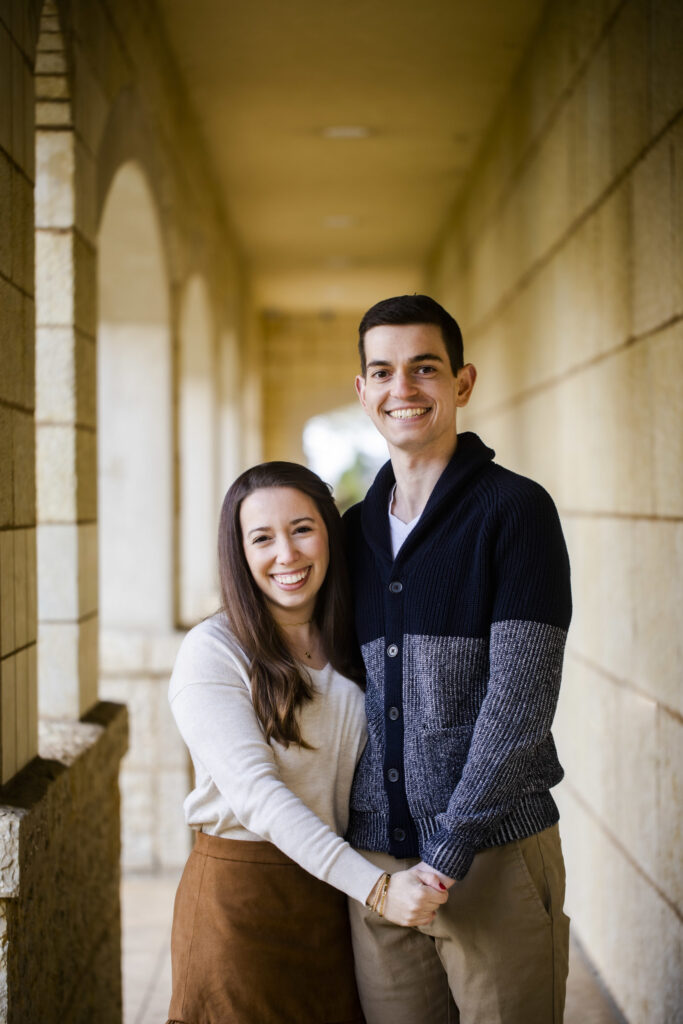 A portrait of brunette couple smiling at the camera.