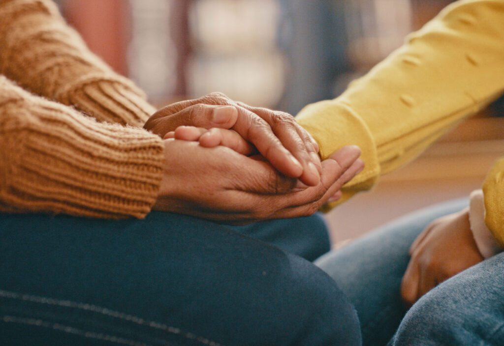A close up of two people holding hands.