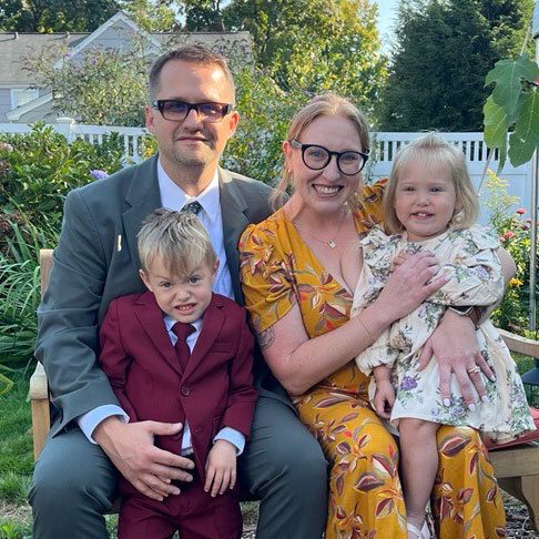 Alice Mintz, her husband and two toddlers in formal clothes posing for a photo.