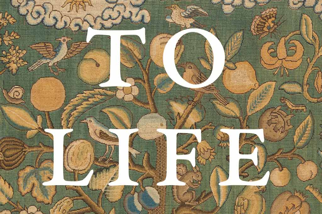 Reads "To Life" with birds/tree embroidery in the background