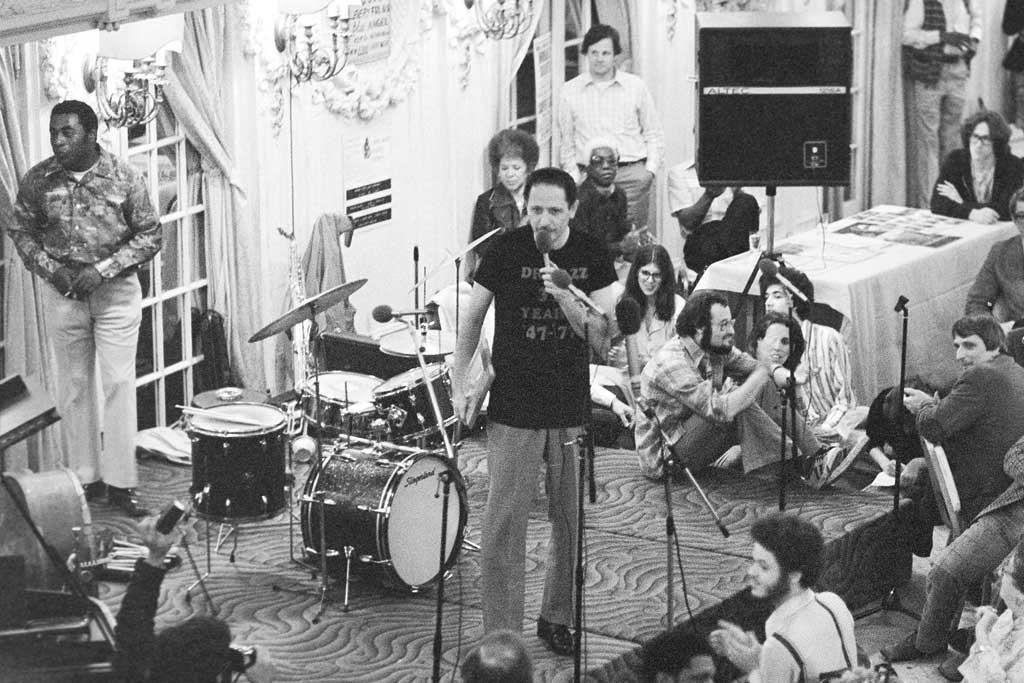 Joe Segal at the microphone in the mid-70s. Standing behind the drums is the great Chicago jazz drummer Wilbur Campbell.  (Photo credit: Jeff Lowenthal.)