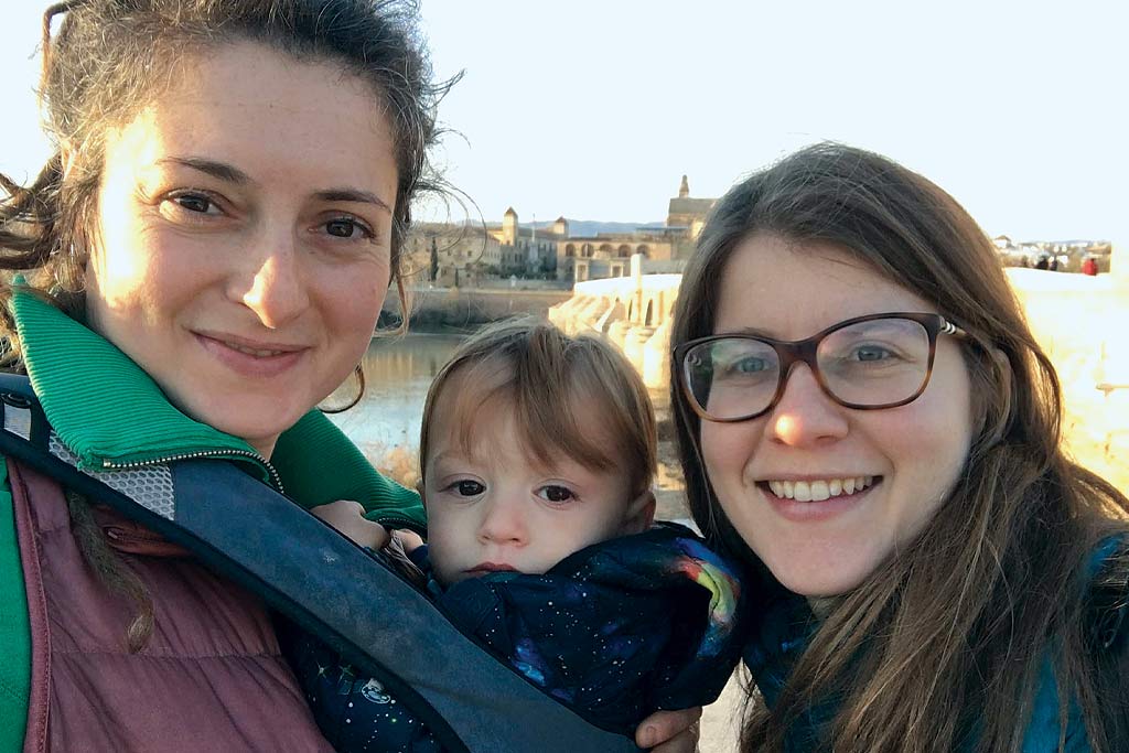 A selfie of two women holding a baby boy