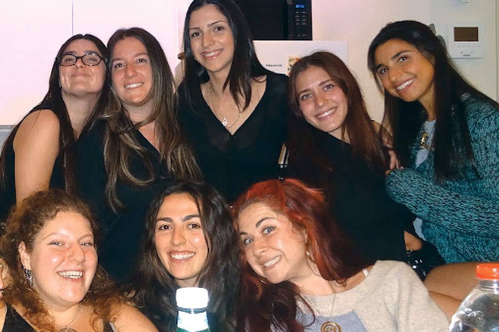 A group of eight young women gathering for dinner in Tel Aviv.
