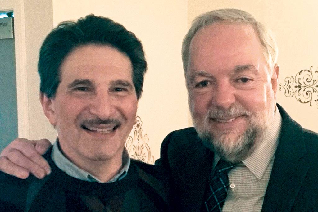 The author (left), with his friend Gary, a non-blood related honorary brother. Two middle aged men smiling together.