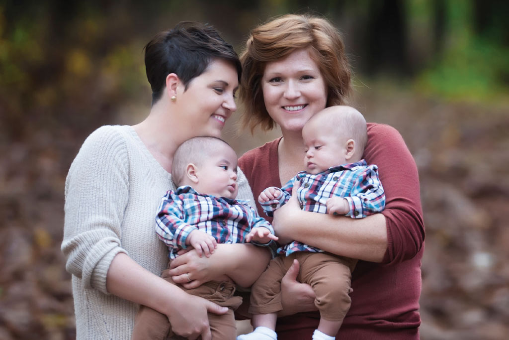 Two women holding twin baby boys.