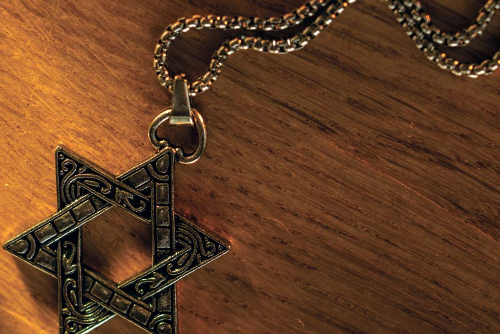 Star of David chain necklace on a wooden surface.