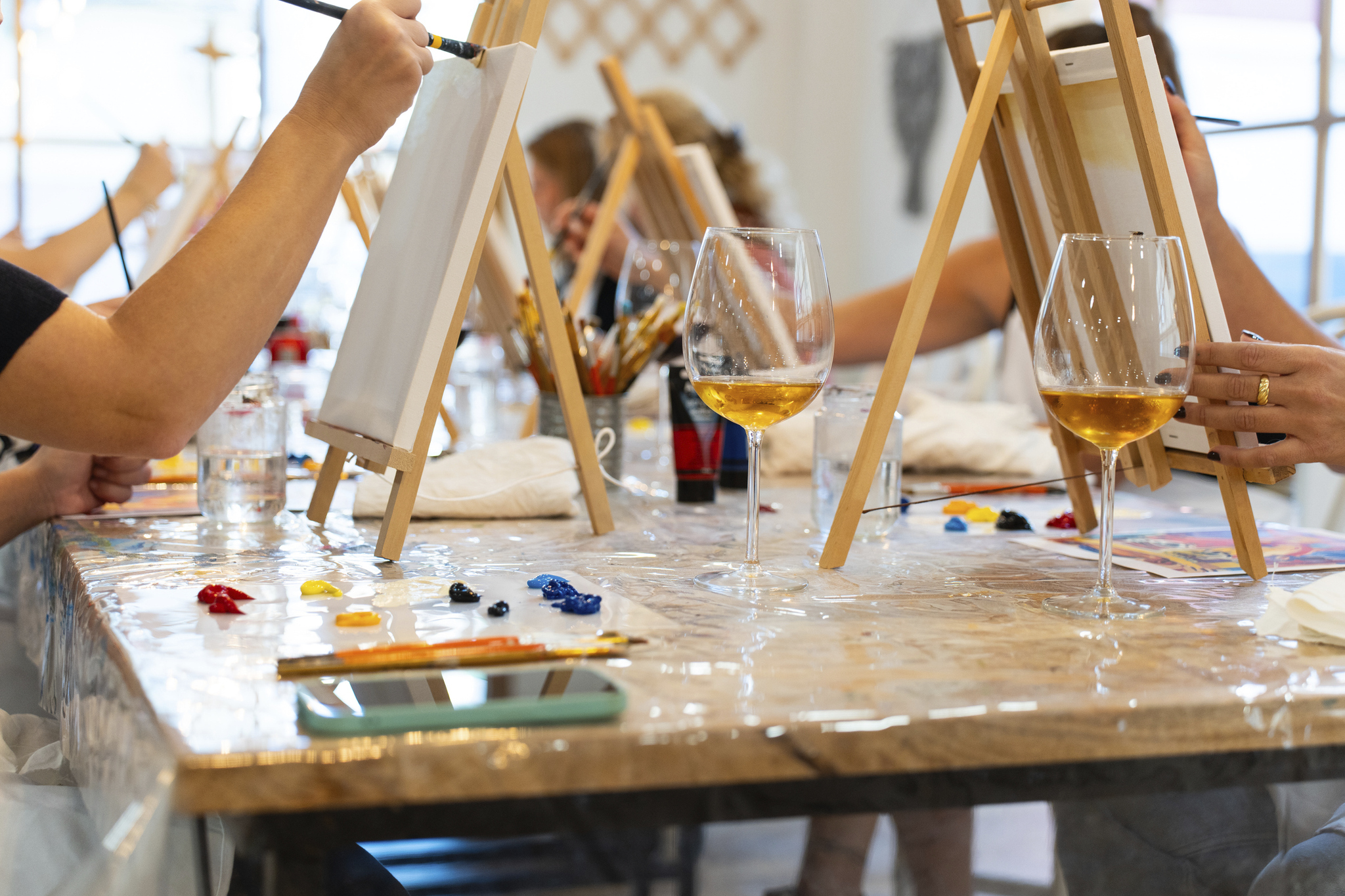 Canvases and wine lasses at a paint and sip night.