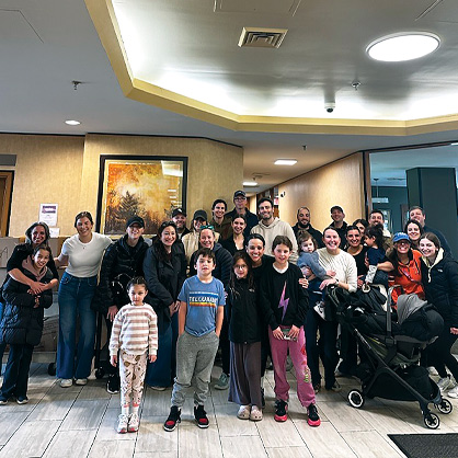 Large group of families of all ages gathered in a lobby.