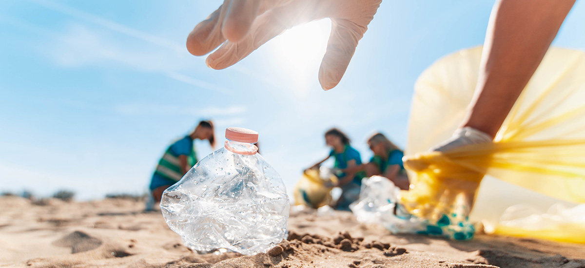 Plastic crunched up water bottle on the beach.