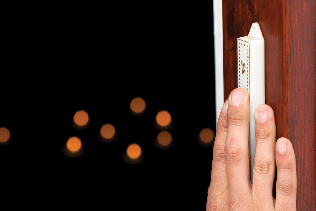 A hand touching a mezuzah