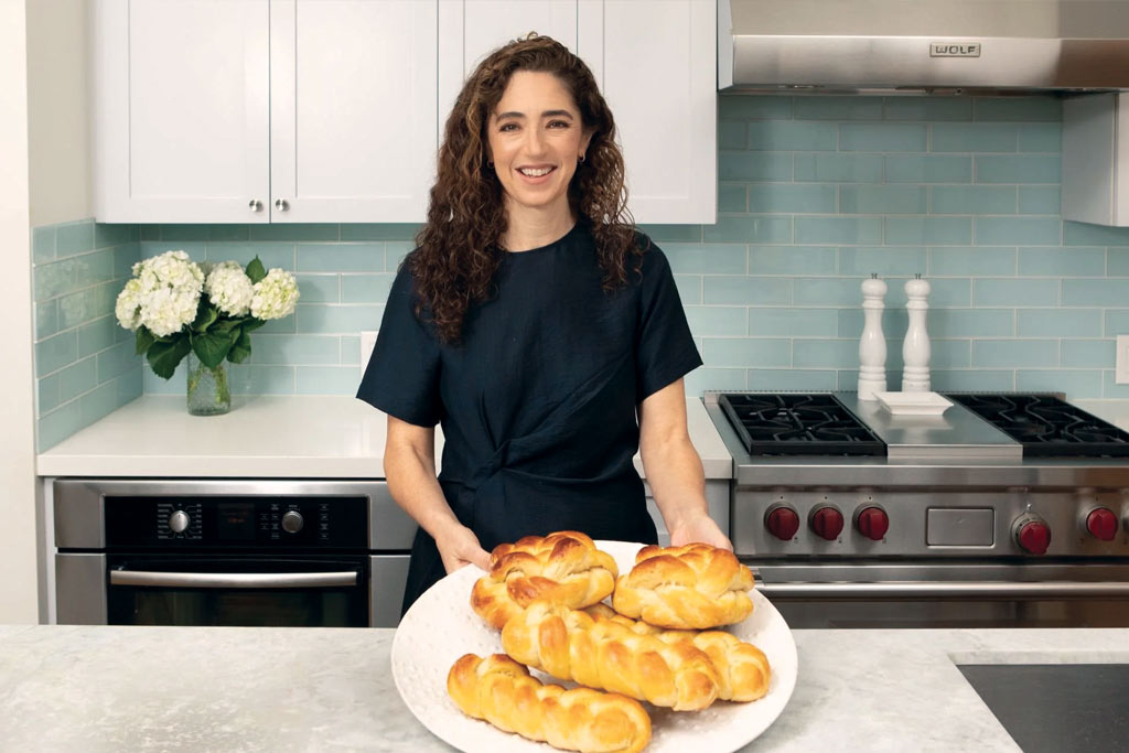 A photo of a women with a plate of challah