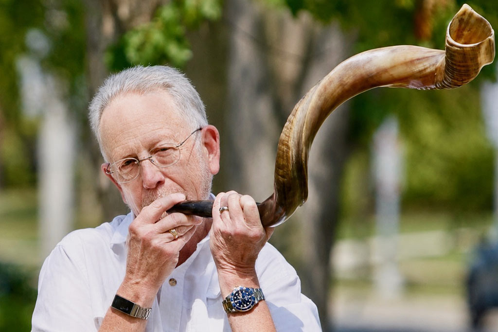 a photo of a man blowing a shofar